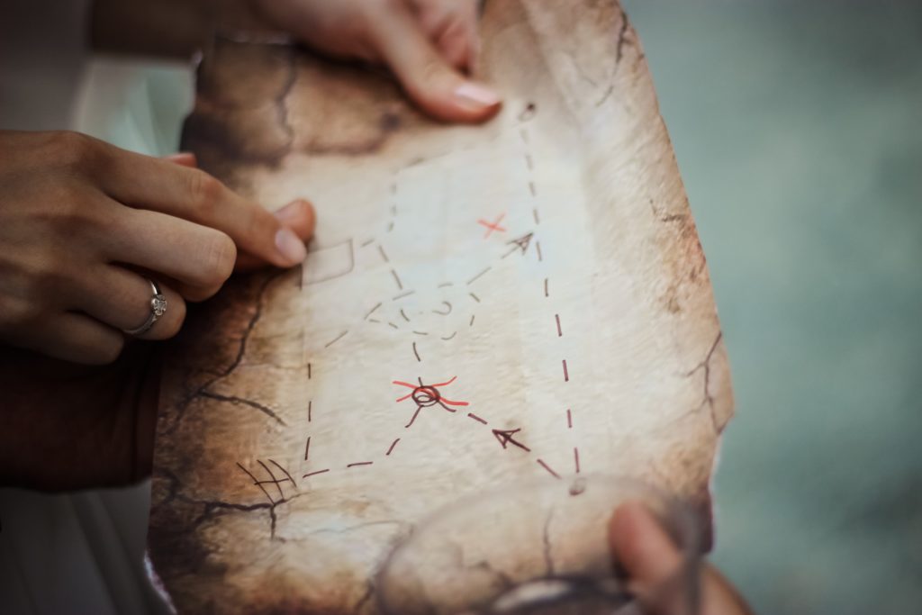 due mani che cercano insieme un punto su una mappa 
